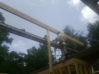 Carpenter setting a ridge beam over a new addition frame — Ice Dam Removal by Roofing Brothers in Middle Point