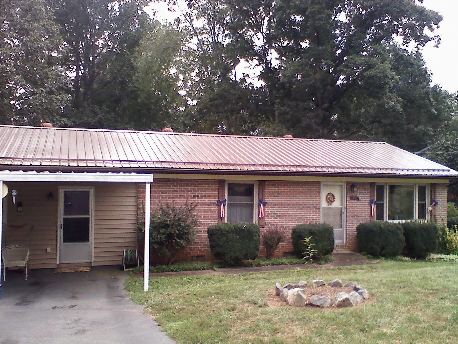Bronze metal roof and carport on a brick ranch home — Roof Repair work by our crew in Middle Point